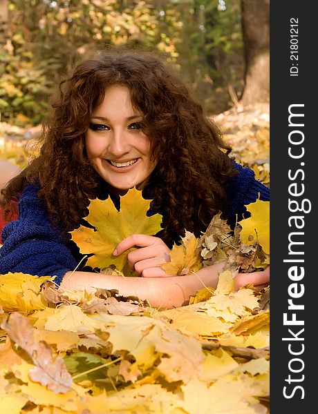 Young woman lying down in the fall leaves. Young woman lying down in the fall leaves