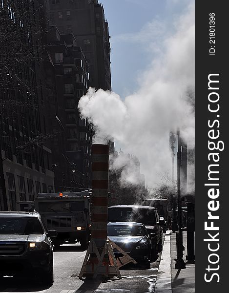 White smoke coming out of a street industrial chimney, photo taken in New York. White smoke coming out of a street industrial chimney, photo taken in New York