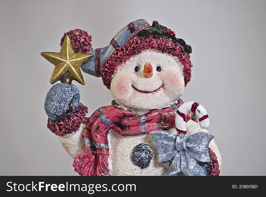 Snowman holding star and candy cane with scarf and mittens