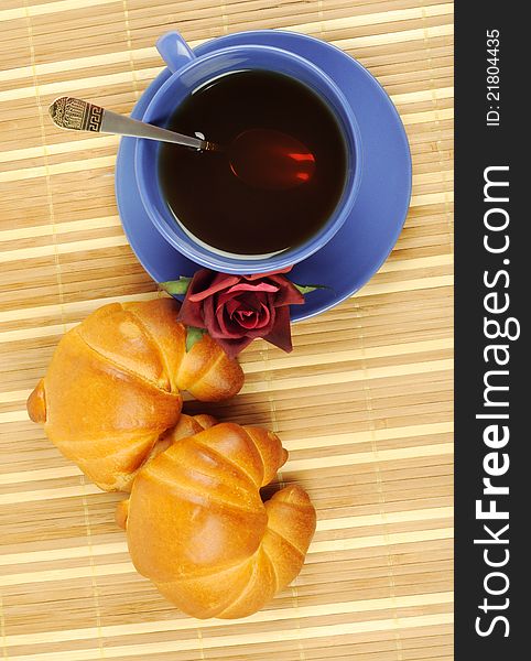 Fresh croissants with cup of tea and red rose over wooden background. Fresh croissants with cup of tea and red rose over wooden background
