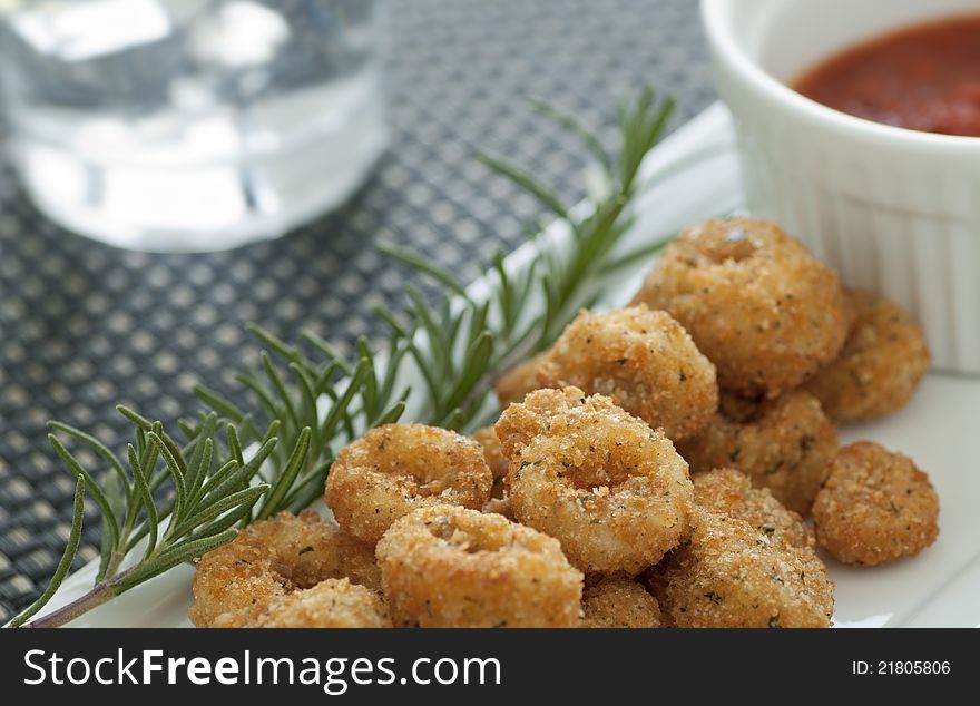 Breaded and deep fried calamari rings with marinara sauce. Breaded and deep fried calamari rings with marinara sauce