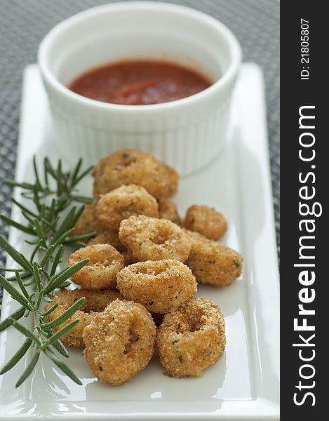 Breaded and deep fried calamari rings with marinara sauce. Breaded and deep fried calamari rings with marinara sauce