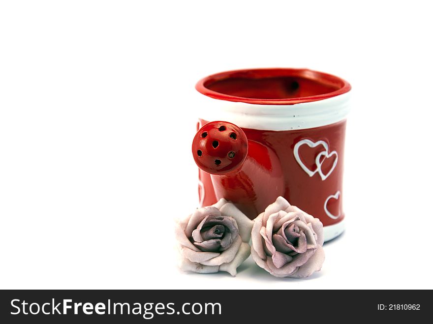 Red watering can with two roses and hearts