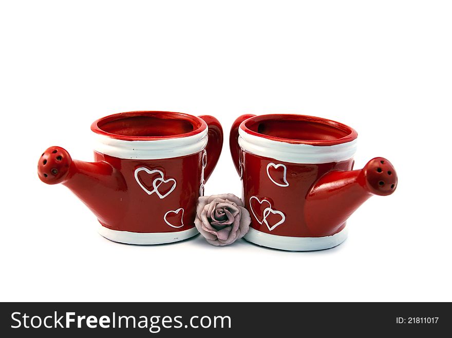 Two red watering cans with hearts