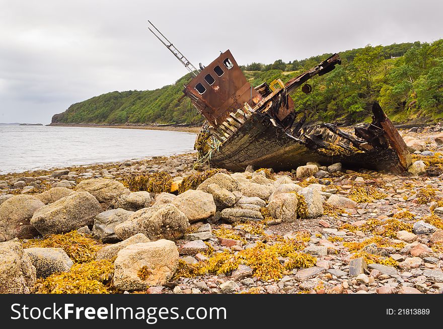 Wreck of a fishing boat stranded on a pebbled beach. Wreck of a fishing boat stranded on a pebbled beach