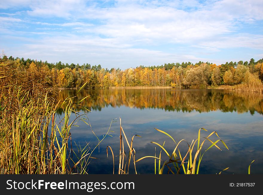 Lake in fall with colored trees and reflections in water. Lake in fall with colored trees and reflections in water