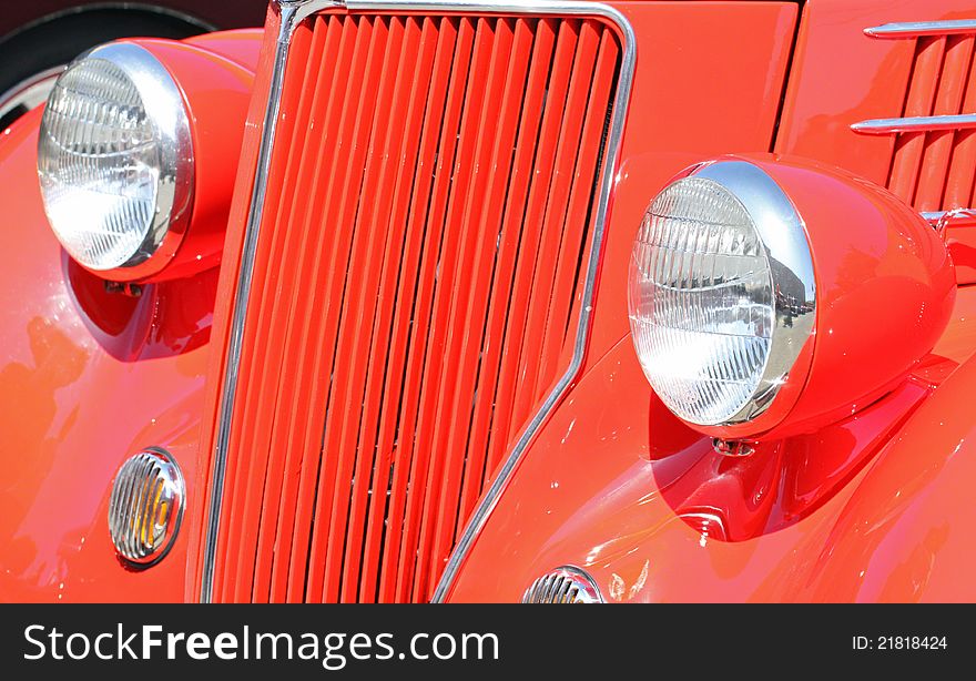 Close Up Detail Of Red Vintage Car grille And Headlights