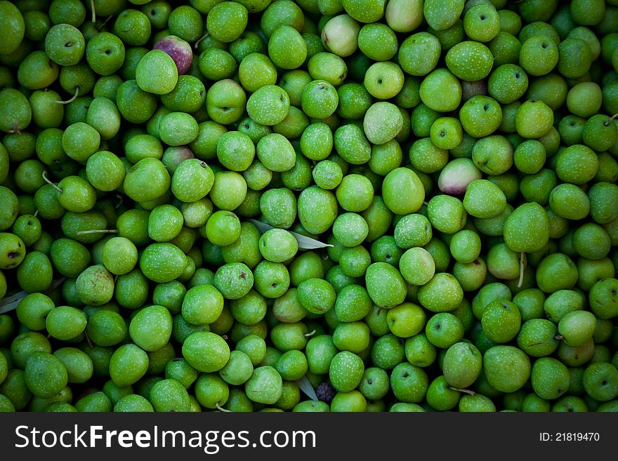 Green olives background in a local market. Natural light.