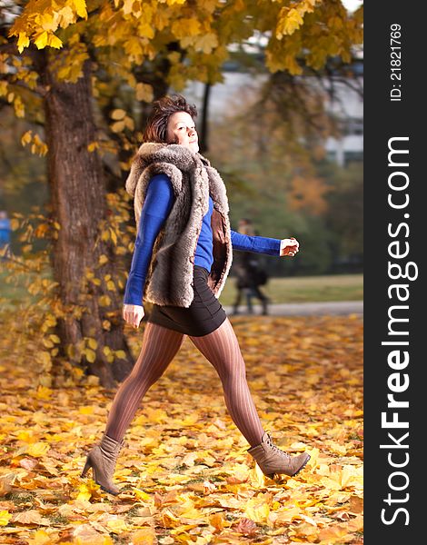 Woman At Autumn Walking On Yellow Leafs