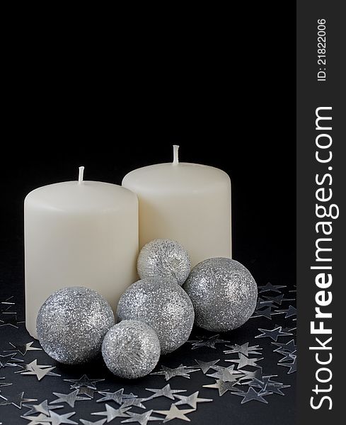 Two candles with silver ornaments on black background. Two candles with silver ornaments on black background