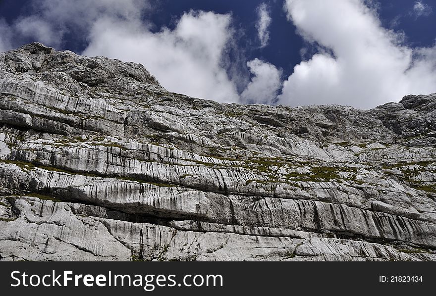 Detail of white rock in Slovenian Alps with blue sky and white cloud. Detail of white rock in Slovenian Alps with blue sky and white cloud