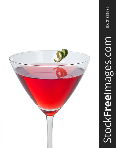 Red cranberry martini with a twist of lime garnish isolated on white. Red cranberry martini with a twist of lime garnish isolated on white