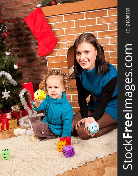 Mother And Her Daughter Near Christmas Tree