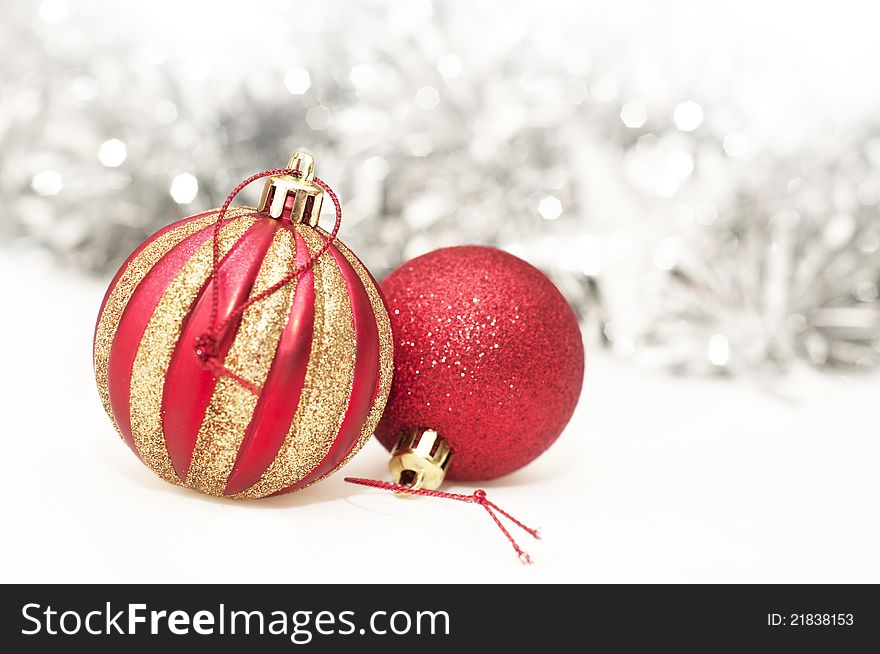 Gold & red christmas baubles with tinsel in the background.