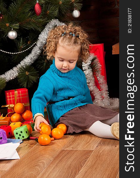 Little girl playing near near Christmas tree. Little girl playing near near Christmas tree