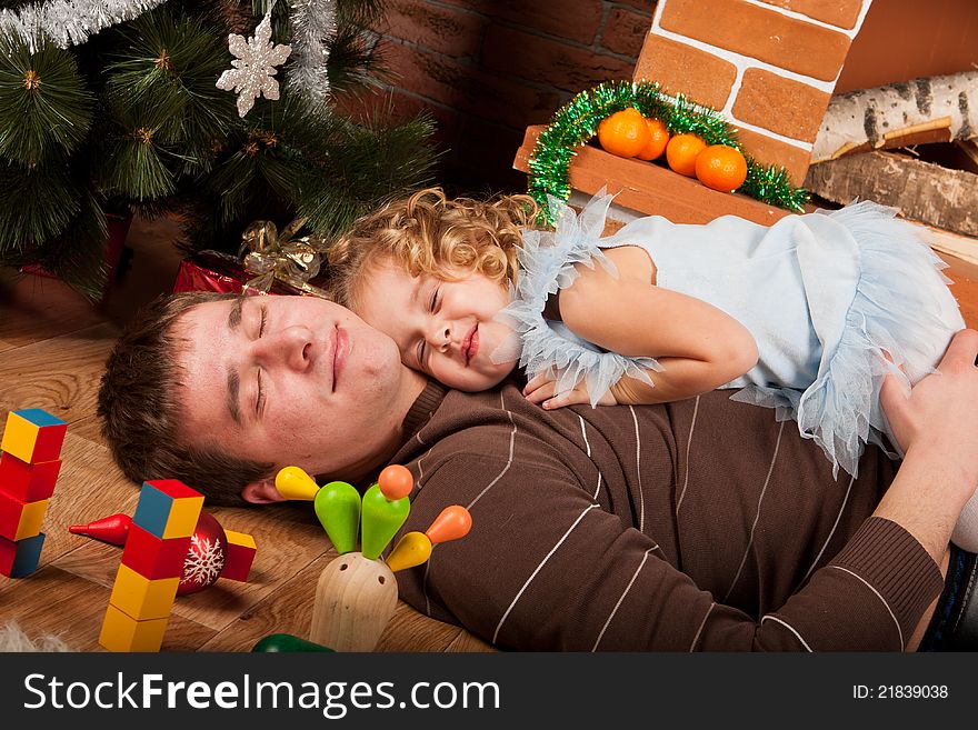 Little girl play with her dad near Christmas tree