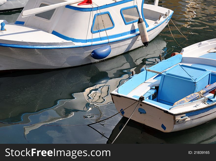 Local fishing boats in the colours of the greek flag in the harbour on the island of symi. Local fishing boats in the colours of the greek flag in the harbour on the island of symi