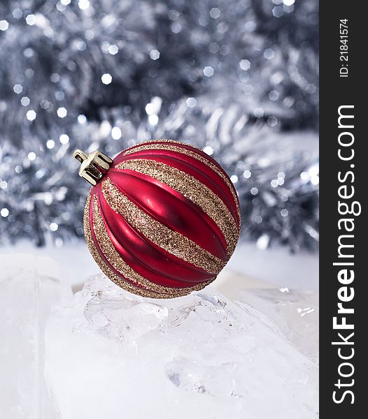 A red christmas bauble with tinsel in the background. A red christmas bauble with tinsel in the background.