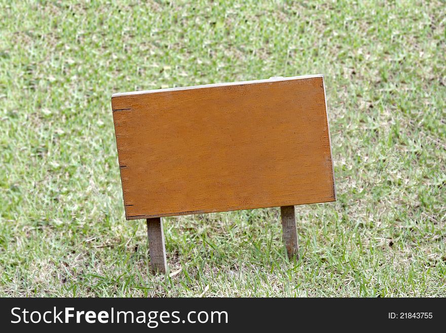 A wooden sign placed on the grassland. A wooden sign placed on the grassland