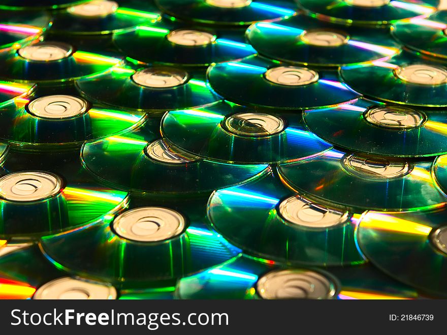 A lot of shiny cd discs lie on each other and shine