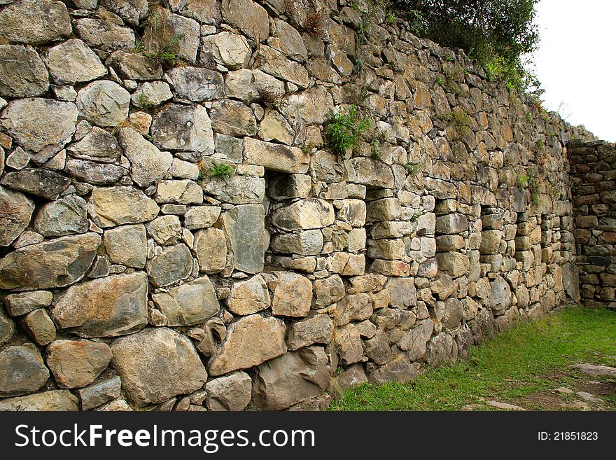 Wall of a fallen house in Machu Picchu ruins.  Inca stone rock wall with spaces (small window like space) for art. Wall of a fallen house in Machu Picchu ruins.  Inca stone rock wall with spaces (small window like space) for art.