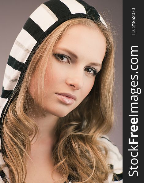 Portrait of pretty young girl in hood with black and white stripes. Portrait of pretty young girl in hood with black and white stripes