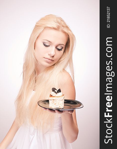 Portrait of pretty girl in white with a cake in her hand. Portrait of pretty girl in white with a cake in her hand