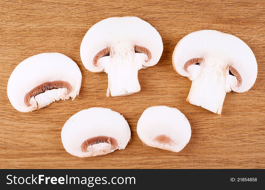 Sliced champignon mushrooms on wooden background