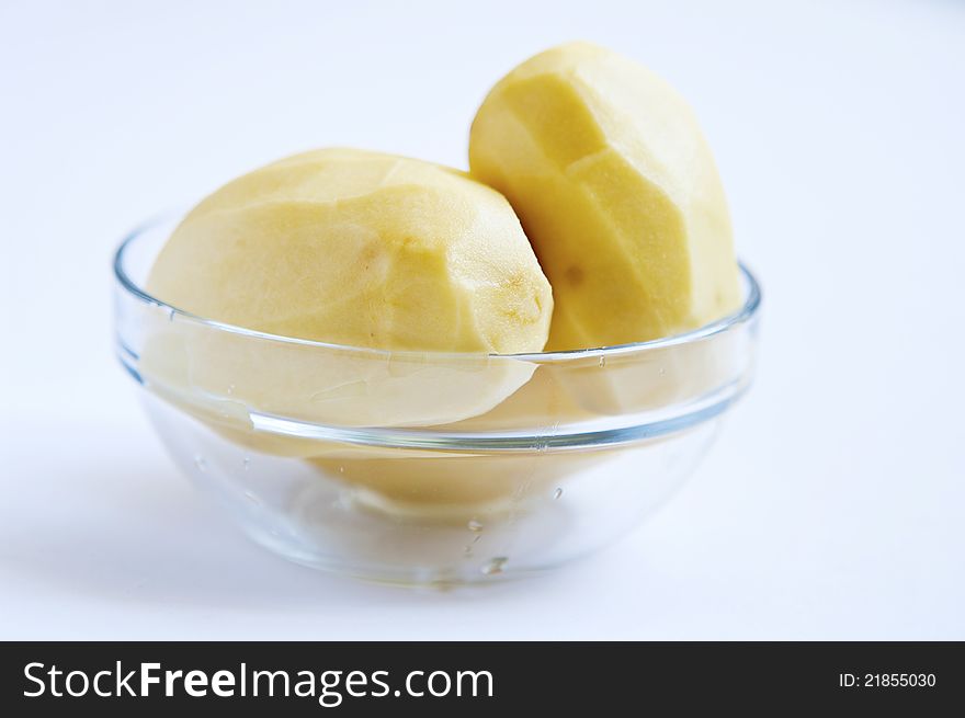 Peeled potatoes in glass bowl close up