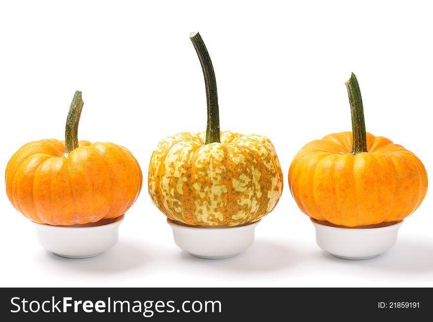 Mini pumpkins in small bowls over white. Mini pumpkins in small bowls over white