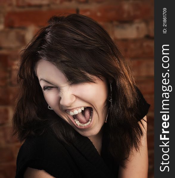 Joyful young girl on brick wall background