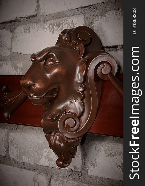 Vintage wooden lion head against brick wall