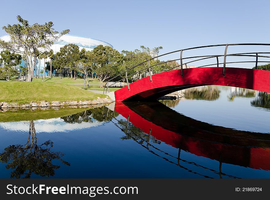 A beautiful outdoor image featuring a red bridge that passes over a man-made lake in Long Beach, California in the Shoreline Village area. A beautiful outdoor image featuring a red bridge that passes over a man-made lake in Long Beach, California in the Shoreline Village area.