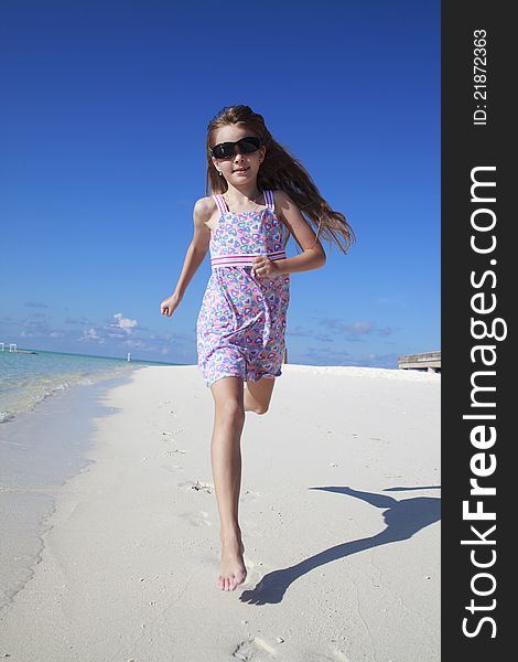 A beautiful caucasian happy girl running on the beach enjoying the summer. A beautiful caucasian happy girl running on the beach enjoying the summer