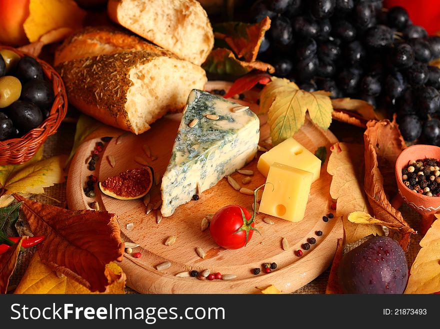 Still life with cheese and autumn fruits