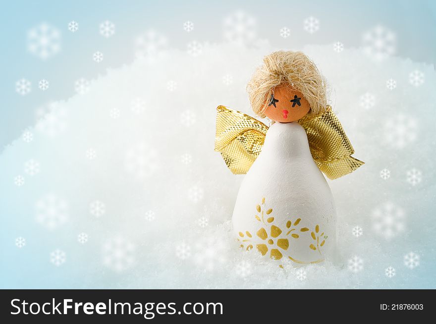 Little cherub with golden wings standing in snow. Little cherub with golden wings standing in snow