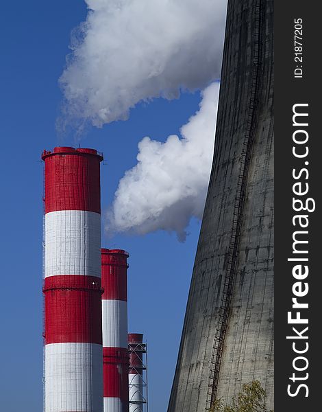 Smoking tubes of a power station on against blue sky