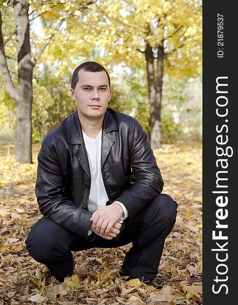 Outdoors portrait of young man in autumn park. Outdoors portrait of young man in autumn park