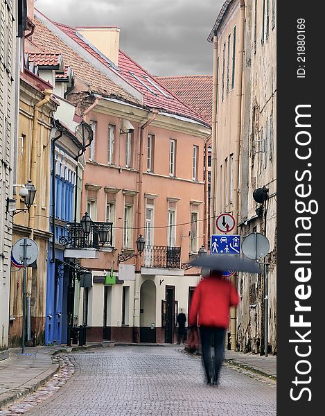 Vilnius oldtown street in a rainy day. Two people - motion blur. Vilnius oldtown street in a rainy day. Two people - motion blur