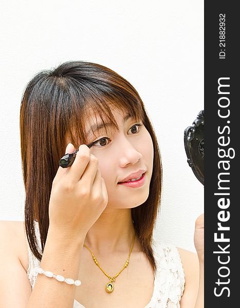 Young cute asian girl using eye liner with her eye. Young cute asian girl using eye liner with her eye