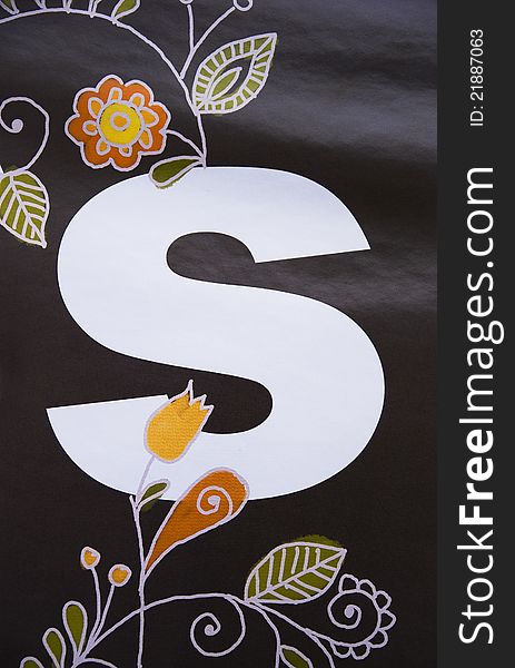 Picture of letter S decorated with hand-painted folk patterns on black background. Picture of letter S decorated with hand-painted folk patterns on black background.