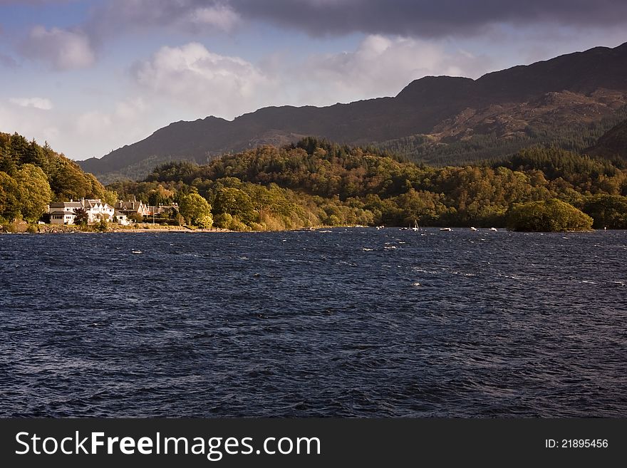 Late sunny afternoon overlooking a scottish wind swept loch with mountains and stormy sky. Late sunny afternoon overlooking a scottish wind swept loch with mountains and stormy sky