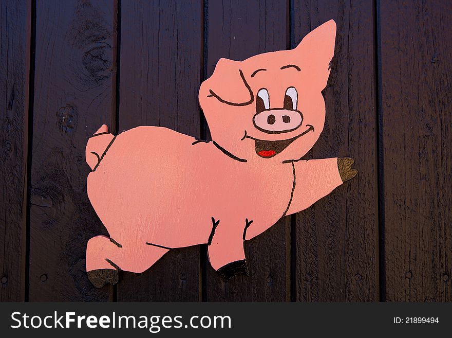 Cartoon wooden painted Pink Pig on black background