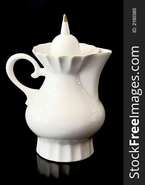 White teapot isolated on a black background