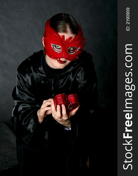 Women in red mask with heart. Make-up black background. Women in red mask with heart. Make-up black background.