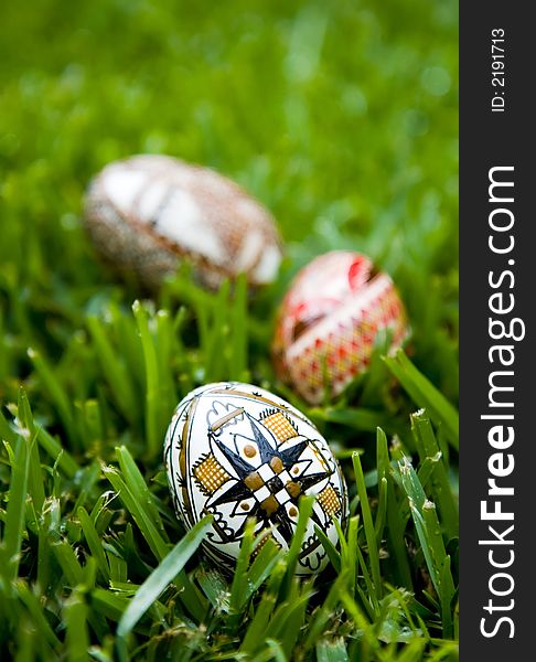 Three hand painted Easter Eggs on bright dew covered grass.  Shallow depth of field, copy space available. Three hand painted Easter Eggs on bright dew covered grass.  Shallow depth of field, copy space available