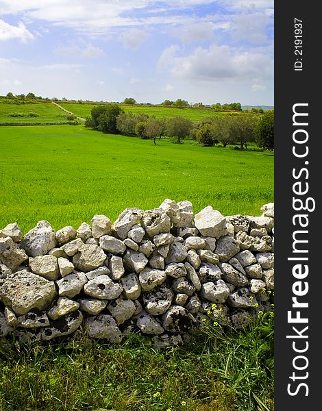 The sicilian landscape, in first plane the caracteristic rock wall