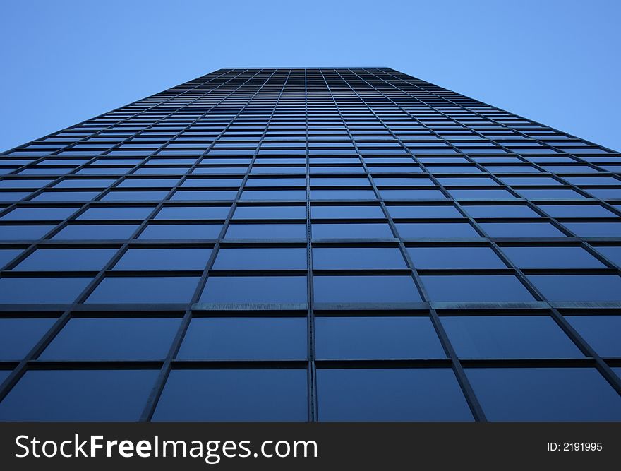 Perspective view of a blue-windowed skyscraper, directly from below. Perspective view of a blue-windowed skyscraper, directly from below.