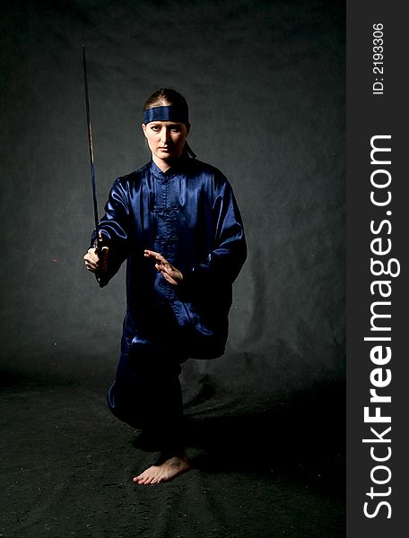 Women in chinese costume with sword - training. Make-up.