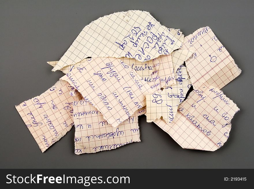 Small group of torn notebook paper isolated over grey. Small group of torn notebook paper isolated over grey
